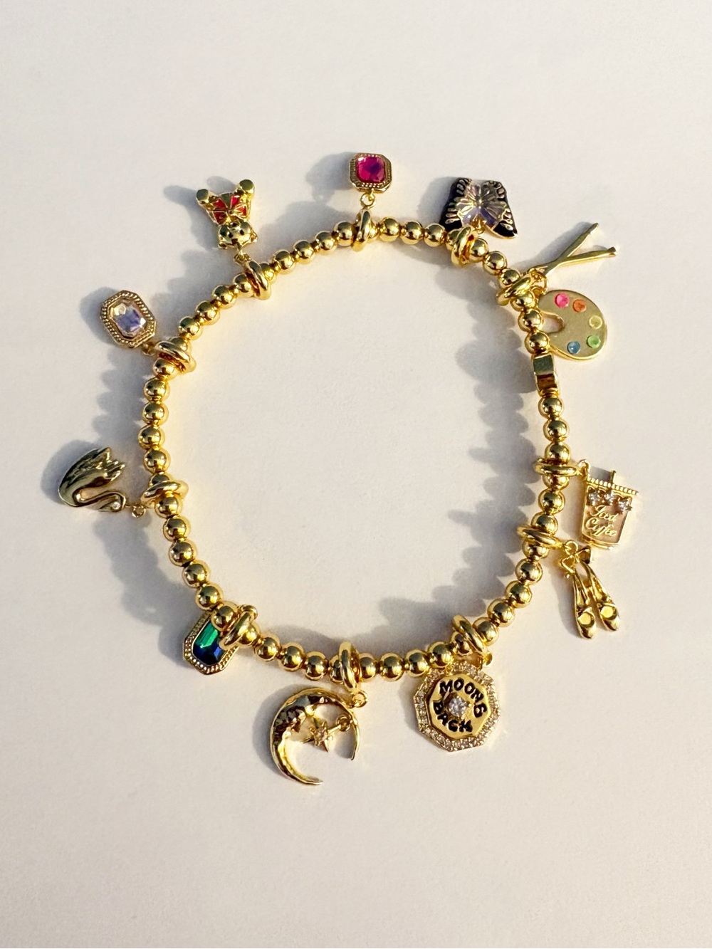 little word project bracelet with moon, butterfly, and art palette charms
